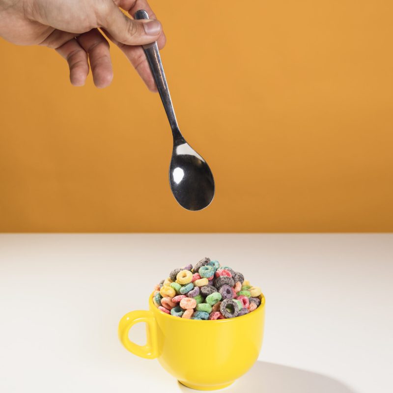 hand-with-spoon-mix-bowl-with-milk-cereals